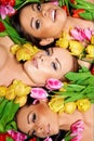 Three beautiful sensual women with colorful tulips