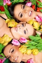 Three beautiful sensual women with colorful tulips