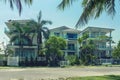 Three beautiful three-story houses with palm trees, trees, in the summer.