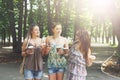 Three beautiful young boho chic stylish girls walking in park. Royalty Free Stock Photo