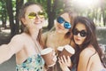 Three beautiful young boho chic stylish girls walking in park. Royalty Free Stock Photo