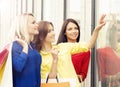 Three beautiful young female shopaholics checking the dress out Royalty Free Stock Photo
