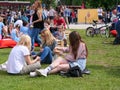 Three beautiful young girls eat sushi sitting in the grass