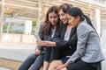 Three beautiful woman sitting on the stairs smartphone share in the city Royalty Free Stock Photo