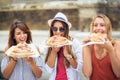 Three beautiful young women eating pizza after shopping Royalty Free Stock Photo