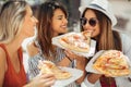 Three beautiful young women eating pizza after shopping Royalty Free Stock Photo