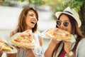 Three beautiful young women eating pizza after shopping Royalty Free Stock Photo