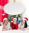 Three beautiful young women lying in front of a Christmas tree Royalty Free Stock Photo