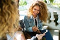 Three beautiful young women using they mobile phone in the street. Royalty Free Stock Photo