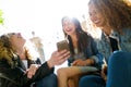 Three beautiful young women using they mobile phone in the street. Royalty Free Stock Photo