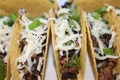 three beef tacos with cheese, lettuce and tomatoes Royalty Free Stock Photo