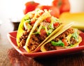 Three beef tacos with cheese, lettuce and tomatoes Royalty Free Stock Photo