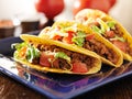 Three beef tacos with cheese, lettuce and tomatoes Royalty Free Stock Photo