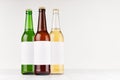 Three beer bottles longneck 500ml different colors with blank white label on white wooden board, mock up. Royalty Free Stock Photo