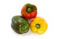 Three bell peppers, green, red and yellow, laying on a flat surface, isolated on white background with a clipping path Royalty Free Stock Photo