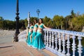 Three belly dancers dressed in light blue leaning on the railing of a bridge. They are talking to each other and looking at the