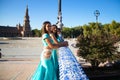 Three belly dancers dressed in light blue leaning on the railing of a bridge. They are talking to each other and looking at the