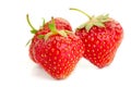 Three berries of ripe juicy strawberries on white table