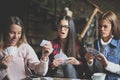 Three best friends in cafe playing together game cards. Royalty Free Stock Photo