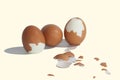 Three big brown eggs is cracking on white background having pieces of egg shell around them, food ingredient for cooking Royalty Free Stock Photo