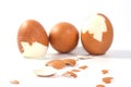 Three big brown eggs is cracking on white background having pieces of egg shell around them, food ingredient for cooking Royalty Free Stock Photo