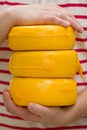 Three big organic cheese heads in yellow vacuum package in man`s hands. Food concept Royalty Free Stock Photo
