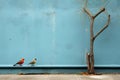 three birds sitting on a wall next to a tree Royalty Free Stock Photo