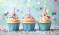 Three Birthday Cupcakes with Lit Candles and Colorful Sprinkles Royalty Free Stock Photo