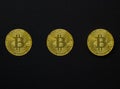 Three bitcoins on a dark background, wallpaper or texture