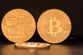 Three Bitcoins, two standing and showing both sides of the coins