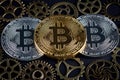 Three bitcoins among various cog wheels closeup. Cryptocurrency concept Royalty Free Stock Photo