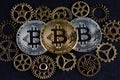 Three bitcoins among various cog wheels. Cryptocurrency concept.. Royalty Free Stock Photo