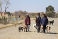 Three black African men with their dogs in a rural area