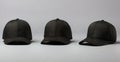 Three Black Baseball Caps on Grey Background with Copy Space Royalty Free Stock Photo