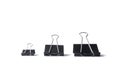 Three black binder clips of various sizes used to staple documents against Royalty Free Stock Photo