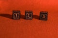 three black dice on a dark orange fabric Royalty Free Stock Photo