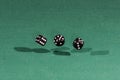 Three black dices falling on a green table Royalty Free Stock Photo