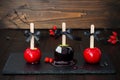 Three black and red poison caramel apples. Traditional dessert recipe for Halloween party. Royalty Free Stock Photo