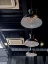 Three black round modern ceiling lights and cassette type air conditioner inside the cafe loft style