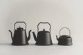 Three black tea kettles sit side by side, perfect for a cozy afternoon gathering Royalty Free Stock Photo