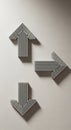 Three black and white arrows on a light gray wall. Each arrow is comprised of parallel vertical Royalty Free Stock Photo