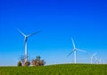 Three Bladed Energy Producing Windmills In Field Royalty Free Stock Photo