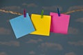 Three blank colorful notes clipped on twine clothesline with clothespins in front of beautiful blue sky. Royalty Free Stock Photo