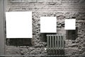 Three blank frames on grey brick wall