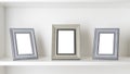 Three blank photo frames on a white shelf Royalty Free Stock Photo