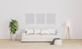 Three Blank poster/picture frames for mockup. Bright living room with white sofa, white modern lamp, plant.  Furnished living room Royalty Free Stock Photo
