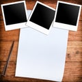 Three blank retro polaroid photo frames and white paper and pen Royalty Free Stock Photo