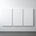 Three blank white canvas panels mounted on a light gray wall Royalty Free Stock Photo