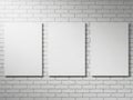 Three blank white frames hanging on a white brick wall Royalty Free Stock Photo