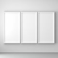 Three blank white picture frames on a light gray wall Royalty Free Stock Photo